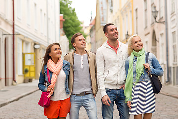 Image showing group of smiling friends walking in the city