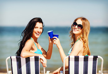 Image showing girls with drinks on the beach chairs