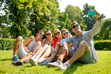 Image showing smiling friends with smartphone making selfie