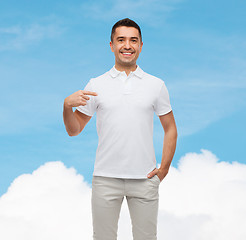 Image showing smiling man in t-shirt pointing fingers on himself