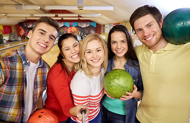 Image showing happy friends taking selfie in bowling club