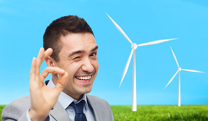 Image showing happy businessman in suit showing ok hand sign