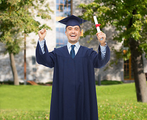 Image showing smiling adult student in mortarboard with diploma