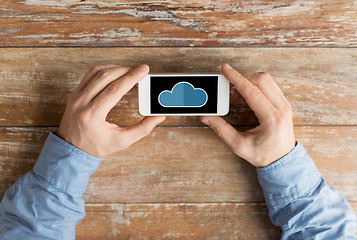 Image showing close up of male hands with cloud on smartphone