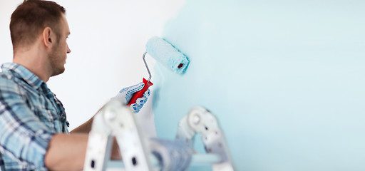 Image showing close up of male in gloves holding painting roller