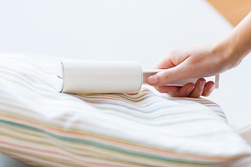 Image showing close up of woman hand with sticky roller cleaning