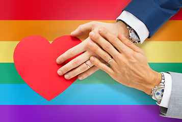 Image showing close up of male gay couple hands with red heart