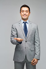 Image showing happy businessman in suit showing empty palms