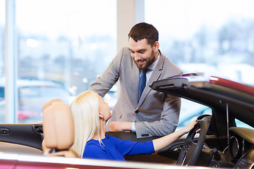 Image showing happy couple buying car in auto show or salon