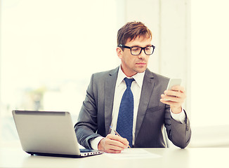 Image showing businessman working with laptop and smartphone