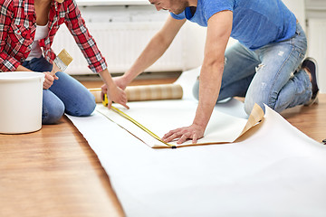 Image showing close up of couple measuring wallpaper