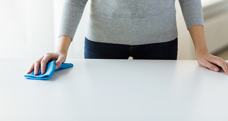 Image showing close up of woman cleaning table with cloth