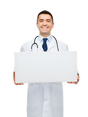 Image showing smiling male doctor holding white blank board