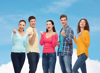 Image showing group of smiling teenagers showing triumph gesture