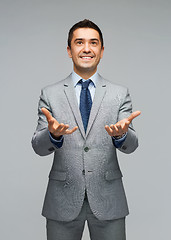 Image showing happy businessman in suit showing empty palms