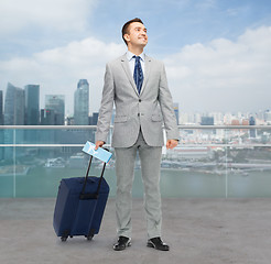 Image showing happy businessman in suit with travel bag