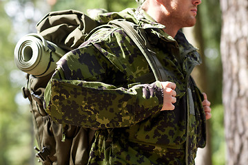 Image showing close up of young soldier with backpack in forest