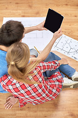 Image showing close up of couple with tablet pc and blueprints