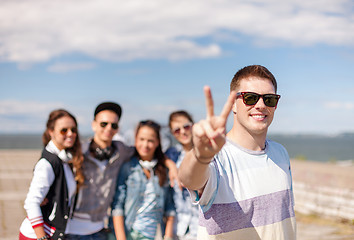 Image showing teenage boy with sunglasses and friends outside