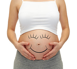 Image showing close up of pregnant woman touching her bare tummy