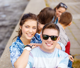 Image showing smiling teenagers in sunglasses having fun outside