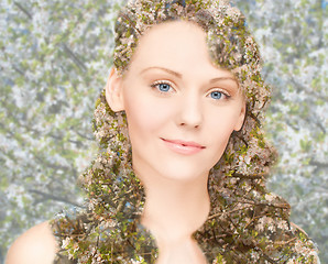 Image showing happy young woman over blooming tree pattern