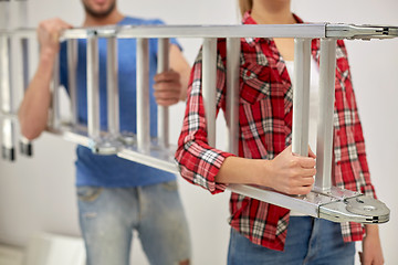 Image showing close up of couple carrying ladder together