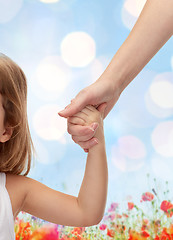 Image showing close up of woman and little girl holding hands