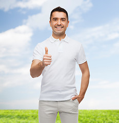 Image showing smiling man in white t-shirt showing thumbs up