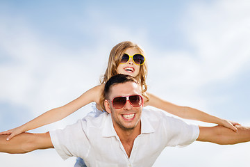 Image showing happy father and child in sunglasses over blue sky