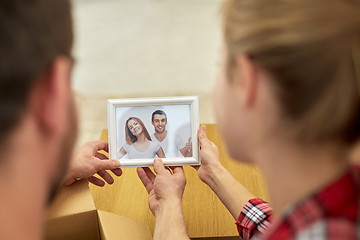 Image showing close up of happy couple looking at family photo