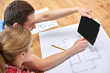 Image showing close up of couple with tablet pc and blueprints