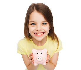 Image showing beautiful little girl with piggy bank