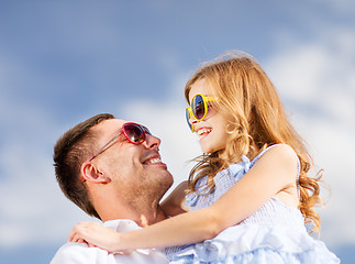 Image showing happy father and child in sunglasses over blue sky