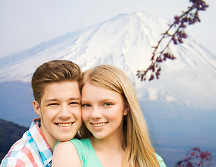 Image showing smiling couple hugging over mountains background