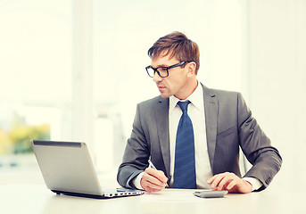 Image showing businessman with computer, papers and calculator