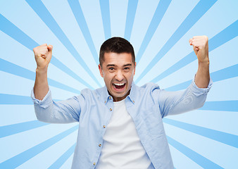 Image showing happy laughing man with raised hands