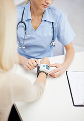 Image showing close up of doctor measuring pulse to patient