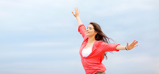 Image showing girl with hands up on the beach