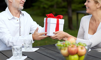 Image showing happy family giving present in summer garden