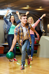 Image showing happy young man throwing ball in bowling club