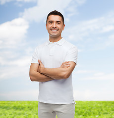 Image showing smiling man in white t-shirt with crossed arms