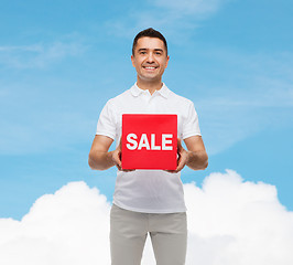 Image showing smiling man with red sale sigh over blue sky