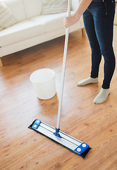 Image showing close up of woman with mop cleaning floor at home