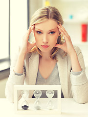 Image showing pensive businesswoman with sand glass