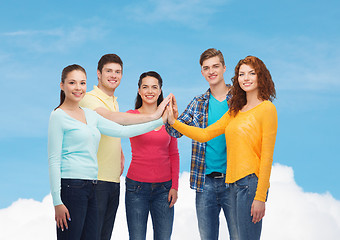 Image showing smiling teenagers making high five