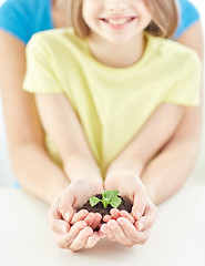 Image showing close up of child and parent hands holding sprout