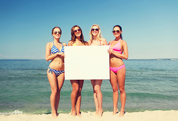 Image showing group of smiling women with blank board on beach