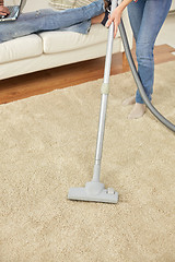 Image showing close up of couple legs and vacuum cleaner at home