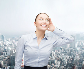 Image showing smiling businesswoman listening gossig